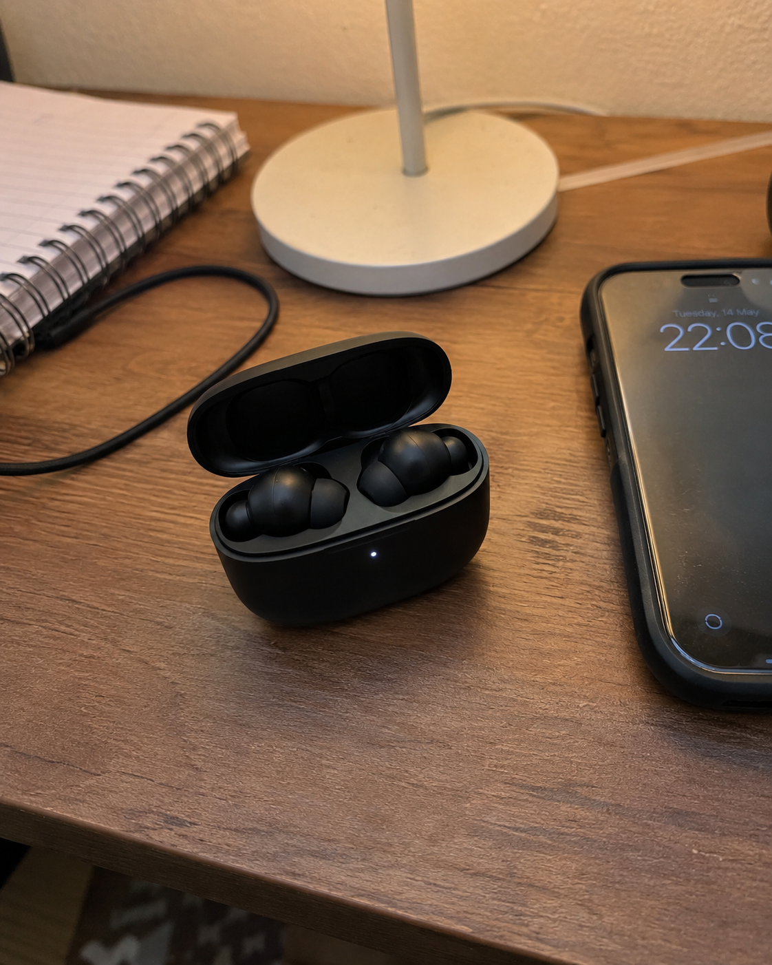 Amateur phone photo of earbuds on a desk